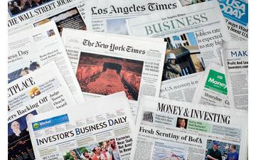 A pile of various newspaper articles.