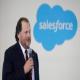 Man holding microphone in front of Salesforce logo.