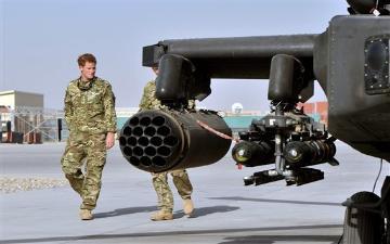 Britain's Prince Harry, left, is shown the Apache helicopter by a member of his squadron (name not provided) at Camp Bastion in Afghanistan, Friday Sept. 7, 2012. Prince Harry will be based at Camp Bastion during his tour of duty as a co-pilot gunner, returning to Afghanistan to fly attack helicopters in the fight against the Taliban. (AP Photo/John Stillwell)