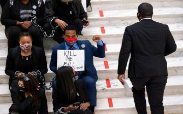 Person holding a protest sign reading 