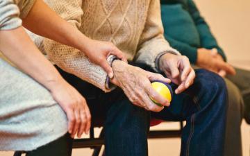 young person holding hand of elderly person image link to story