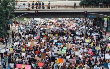 A large crowd of people holding protest signs.