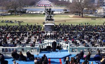 A large crowd attending a presidential inauguration ceremony with a stage in the center.