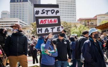 People at a rally holding a sign that says 