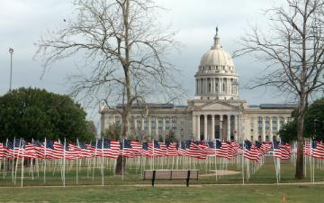 Alt text: Oklahoma State Capitol with numerous small American flags on the lawn.