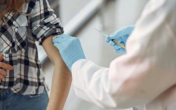 A healthcare professional administering a vaccine to a person.