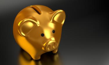 Golden piggy bank on a dark reflective surface.