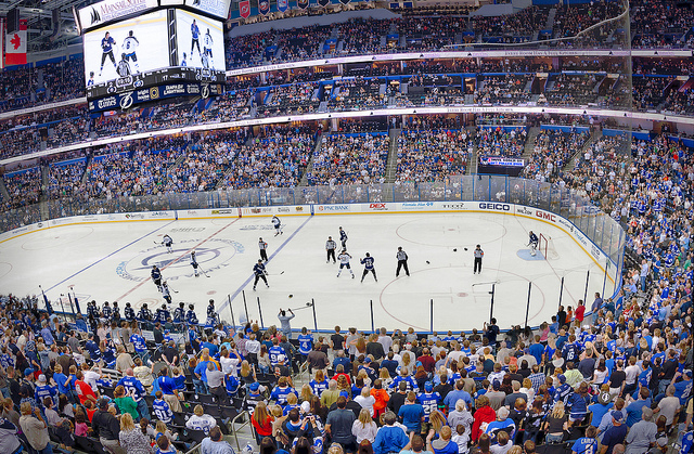 Alt text: Ice hockey game in a large stadium with a cheering crowd.