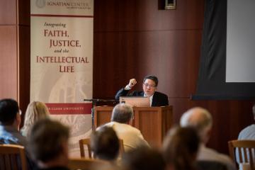 A person speaks at a podium to an audience.