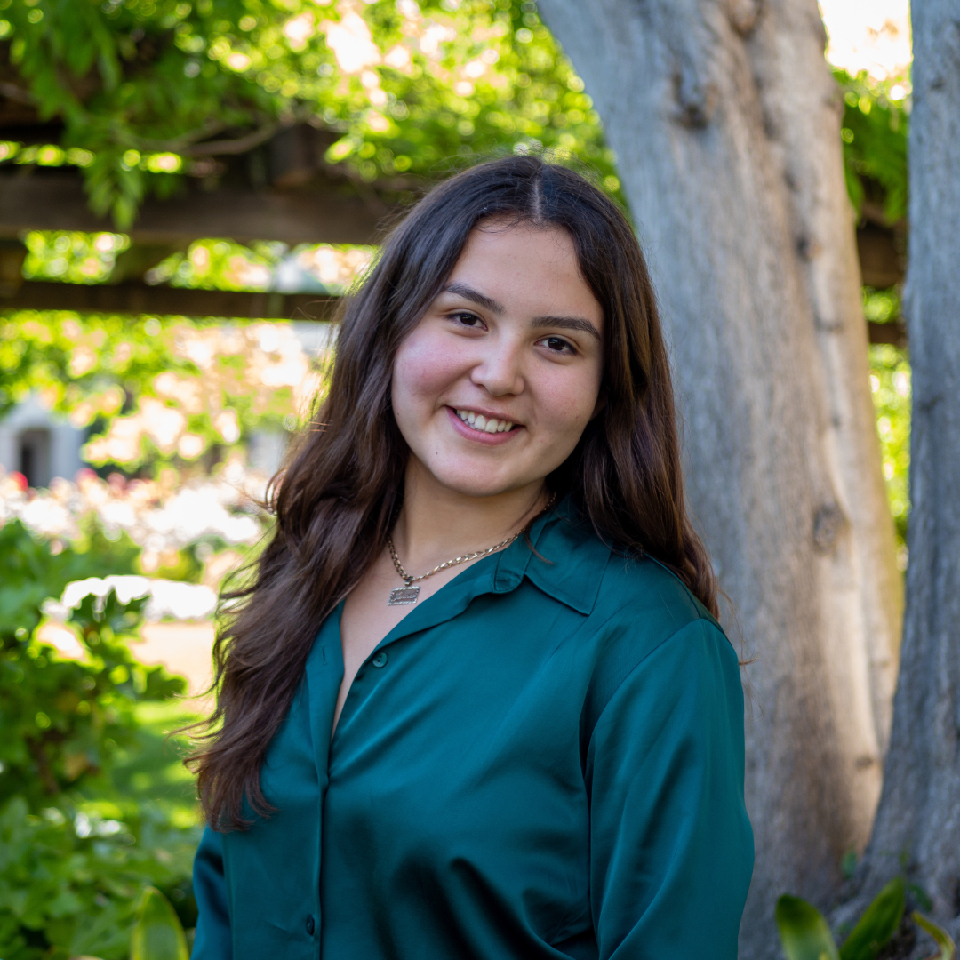 A student standing in front of a tree 