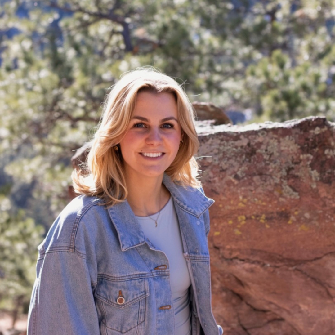 A student in front of trees and rocks 