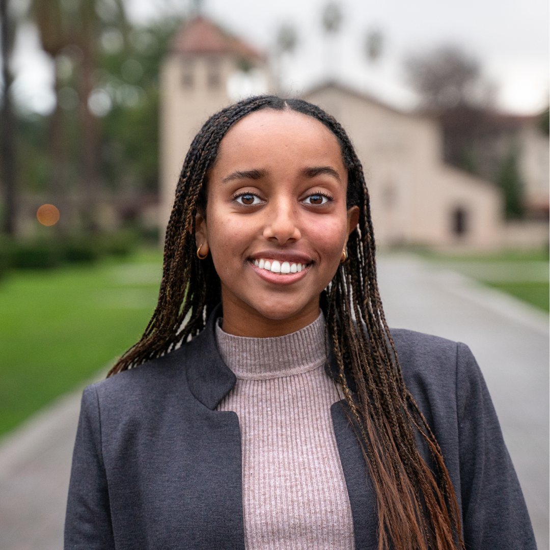 A photo of a student in front of the Santa Clara Mission 