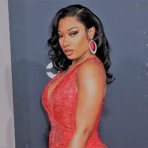 Megan Thee Stallion in a red dress with earrings.