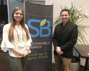 Two individuals posing in front of SBB banner.