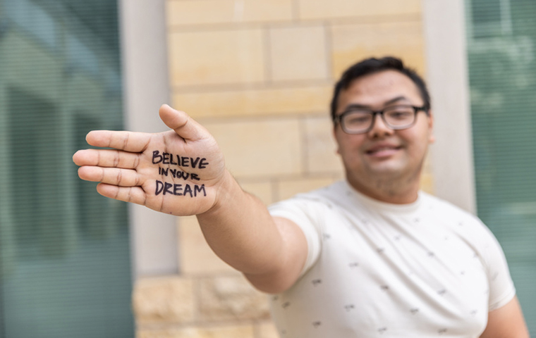 St. Thomas student with writing on hand that says 