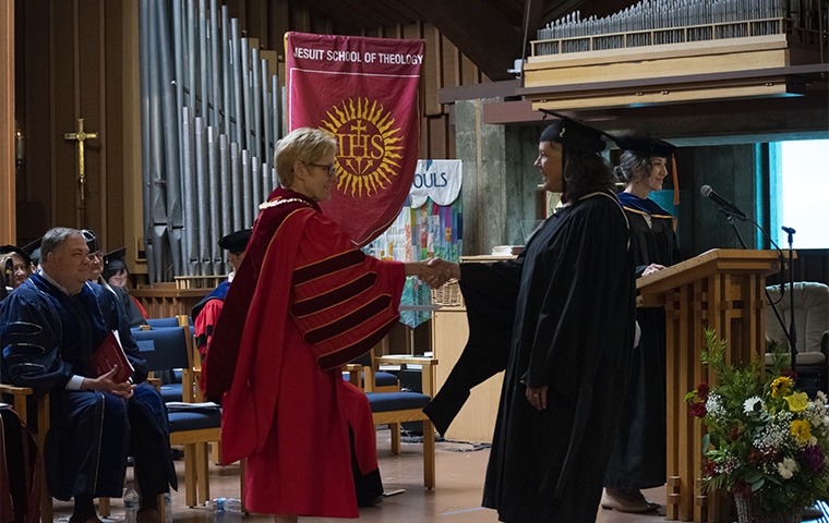 President Sullivan shaking hands with a JST graduate at Commencement 2023