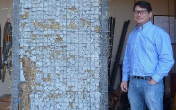 Mark Aschheim standing next to a straw bale wall specimen he tested at SCU in 2015.