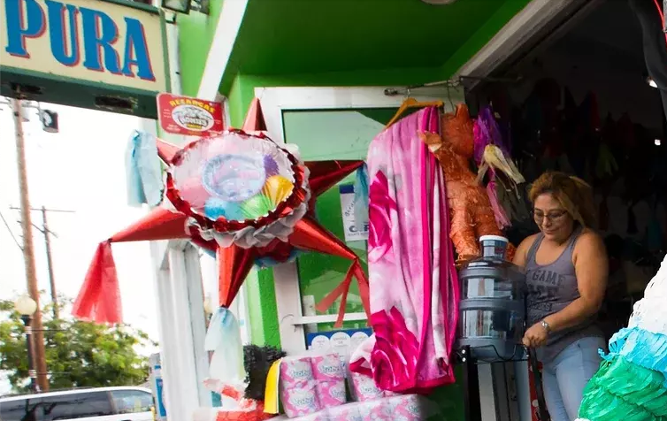 A woman in Calle Willow takes a water jug outside of a store