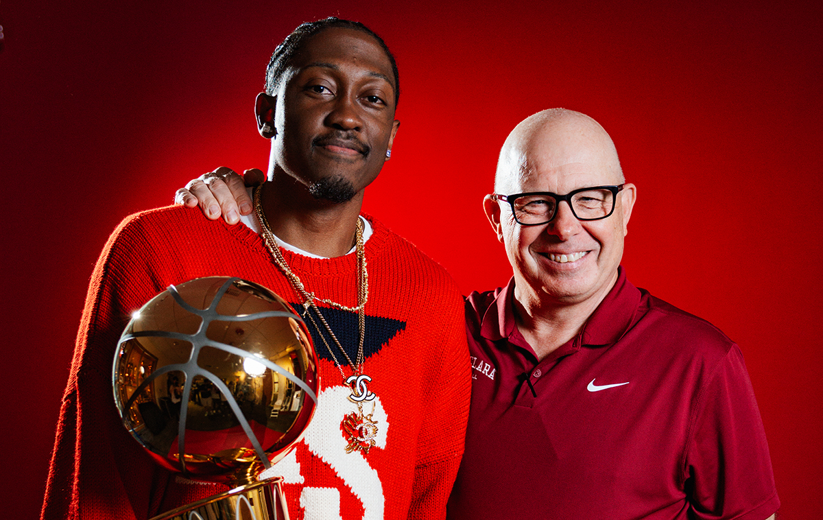 Jalen Williams holding NBA championship trophy and Santa Clara Head Coach Herb Sendek in front of red backdrop