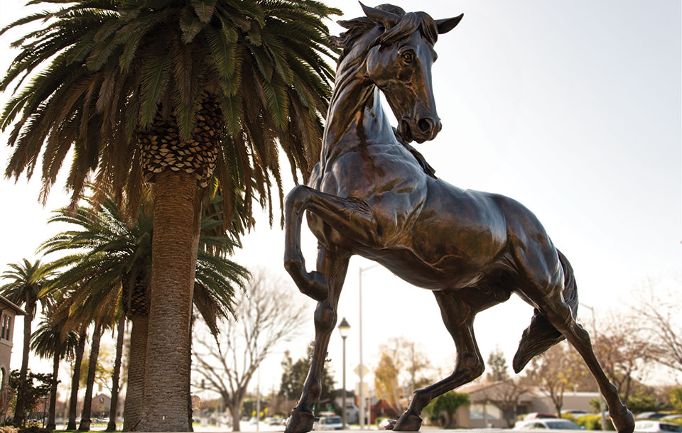 Bronco horse statue rearing near palm trees. image link to story