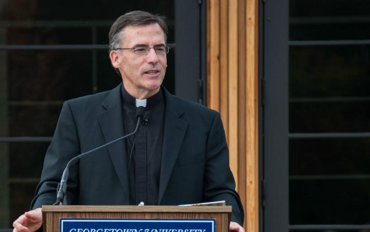A person in clergy attire speaking at a podium. image link to story