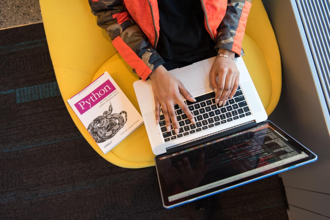 Photo of woman using Python computer coding.