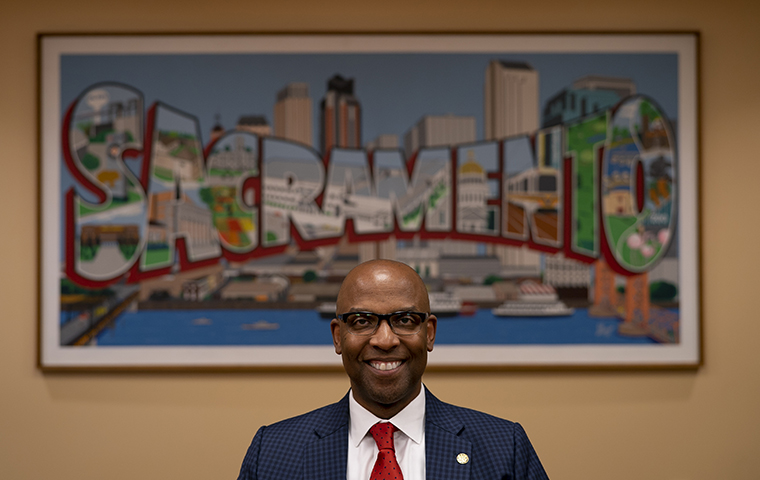 Louis Stewart seated in front of an illustration spelling out Sacramento