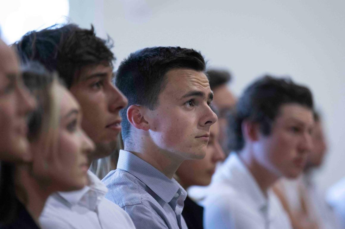 People seated and attentively listening during an event.