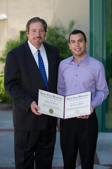 Two men posing; one holds a certificate labeled 