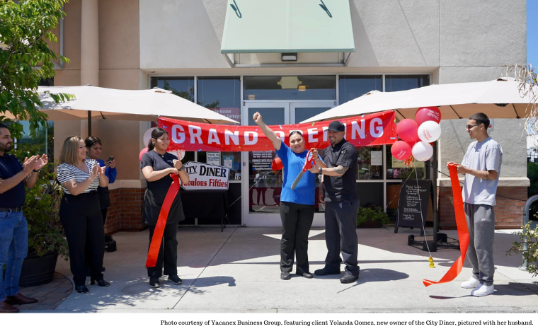 A ribbon-cutting ceremony with six people in front of a building.