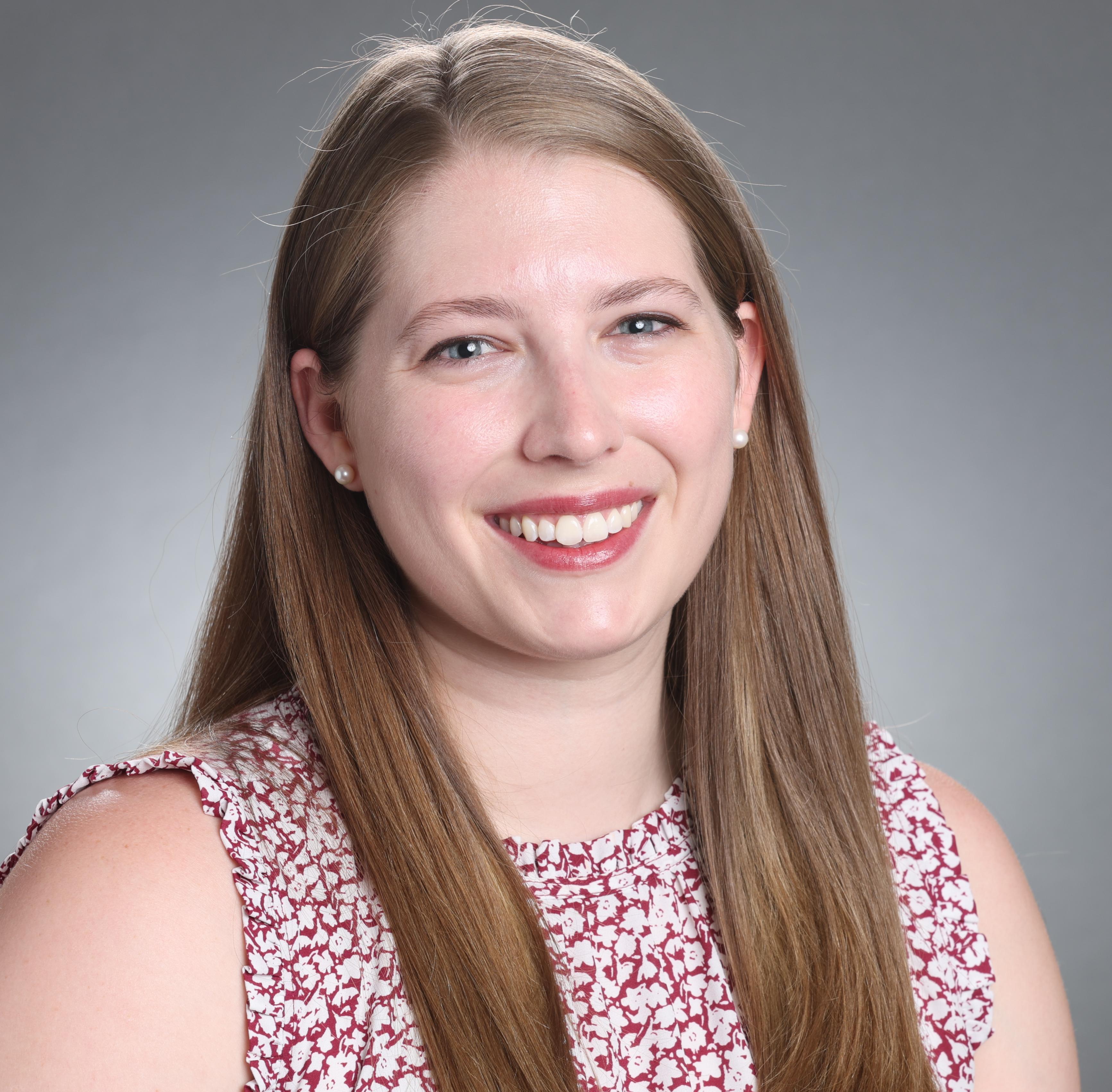 A person smiling against a plain background.