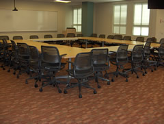 A conference room setup with a square table arrangement and chairs.