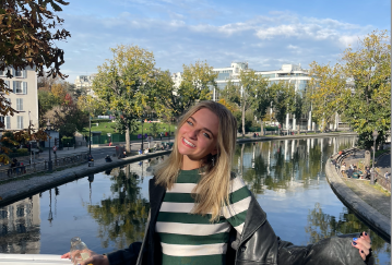 A person enjoys a sunny day by a peaceful river.