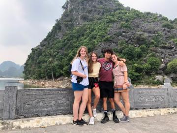 A group of people posing in front of a mountain.