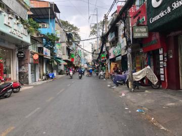 Alt text: Busy street in Ho Chi Minh City with scooters and shops.