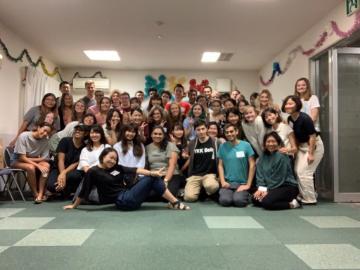 A large group poses together in a decorated room.