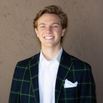 A person wearing a suit jacket with a white shirt and pocket square.