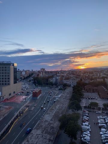 Sunset over a cityscape with buildings and trees.