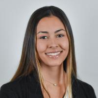 A person in a professional headshot wearing a black blazer and white shirt.