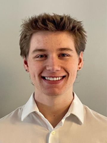 A person smiling in a white shirt.