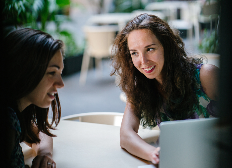 Two women talking with a laptop