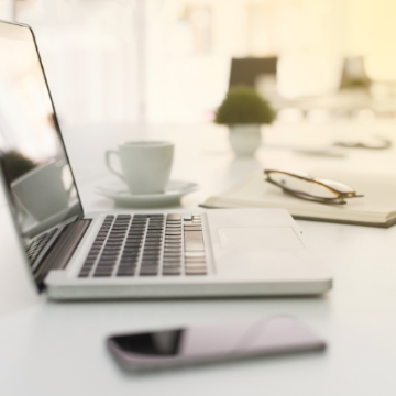 Photo of laptop, phone, and coffee on a desk