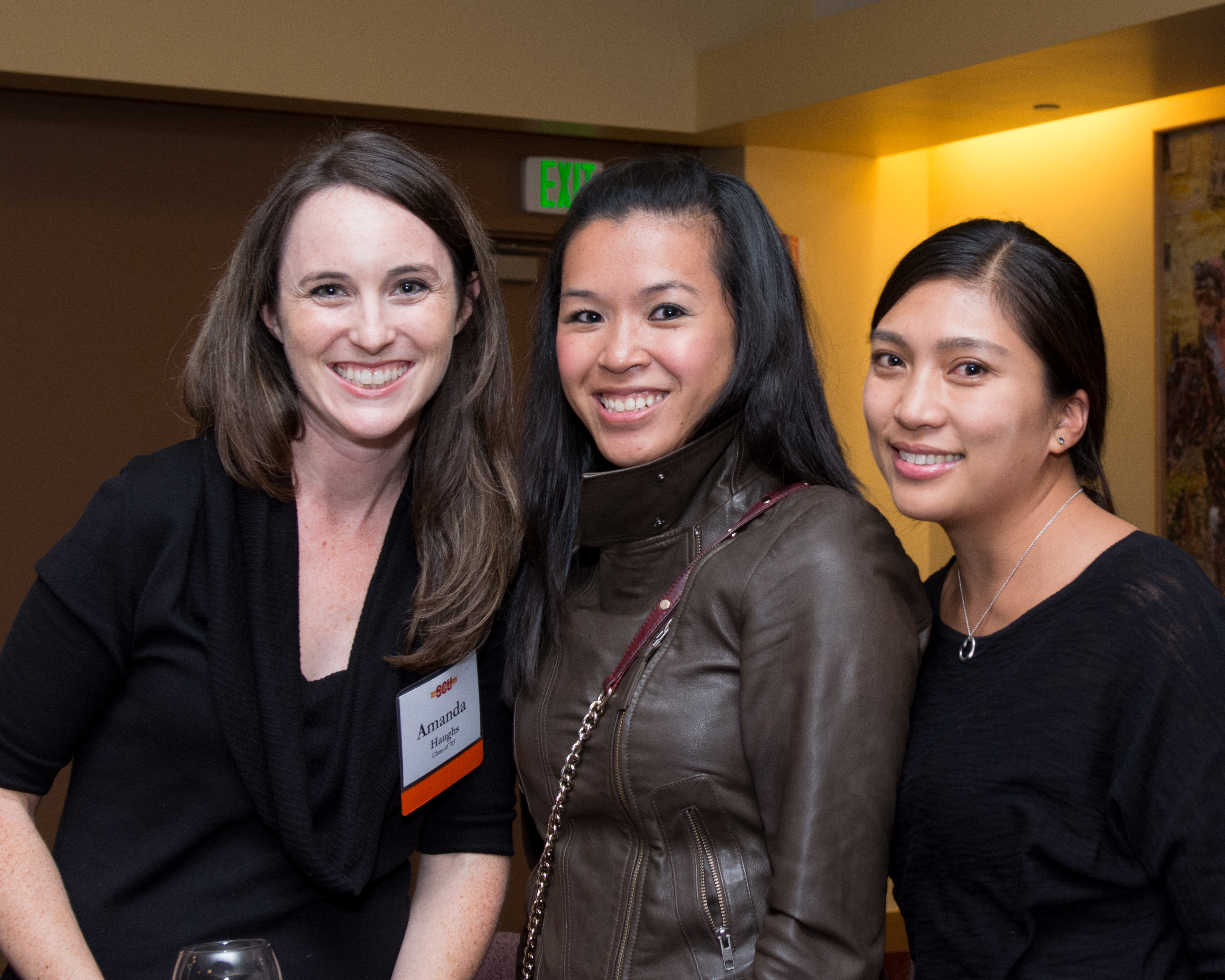 Three people posing and smiling at an indoor reception in Las Vegas.