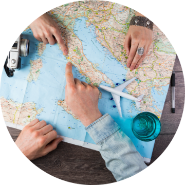 Hands pointing on a map with travel items around.