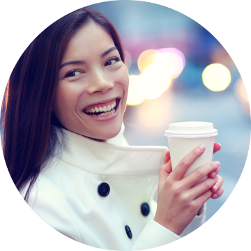 Woman smiling while holding a coffee cup.