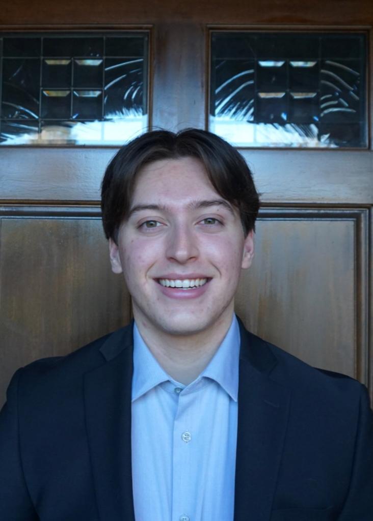 A person in business attire smiling for a professional headshot.