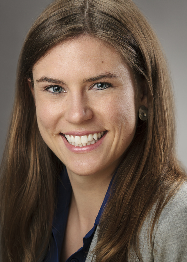 A person smiling in a professional headshot.