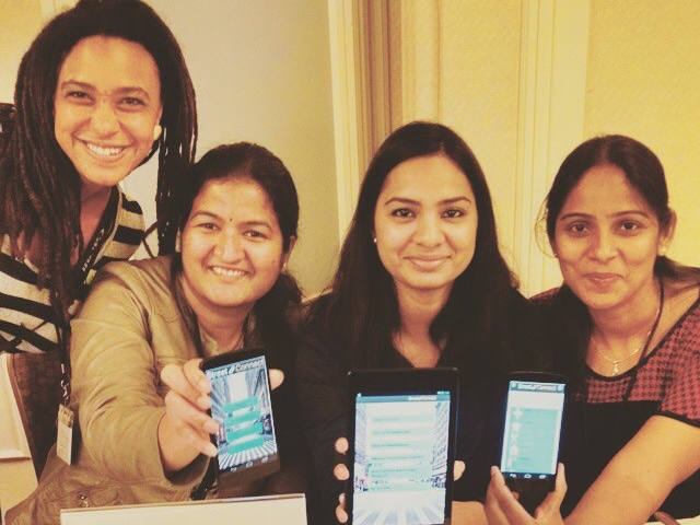 Four women smiling and each holding a smartphone displaying an app. image link to story