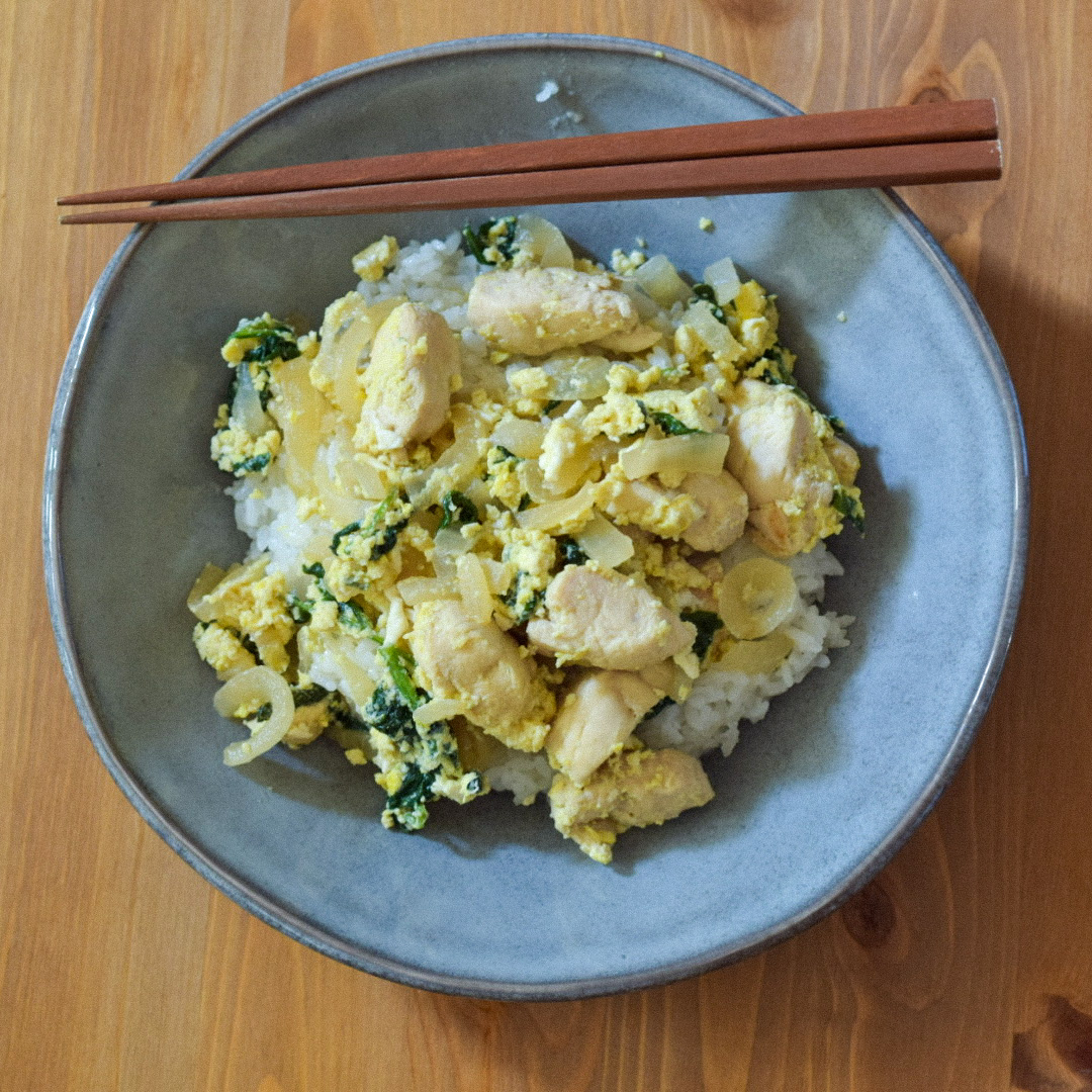 A bowl of Oyako Donburi with chopsticks on the side.