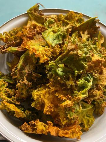 A plate of kale chip pakoras with mixed vegetables.
